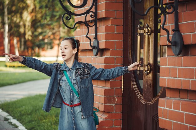 Girl in jeans clothes near old building of red brick