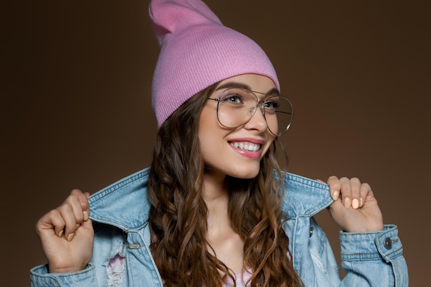 Girl in jeans jacket  a pink hat and stylish glasses