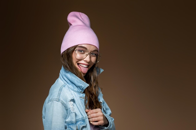 Girl in jeans jacket  a pink hat and stylish glasses