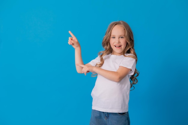 girl in jeans and a white T-shirt points her finger at something, a place for text