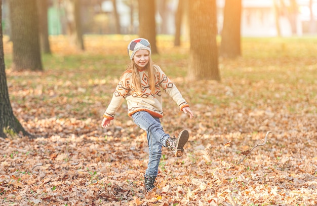 Girl kicking autumn leaves