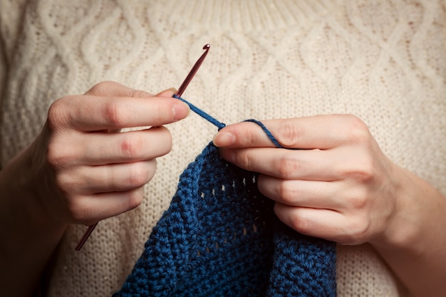 Photo the girl knits from knitting yarn. crochet thick threads. home comfort.