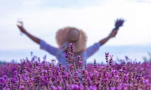 A girl in a lavender field pours wine into a glass Relaxation