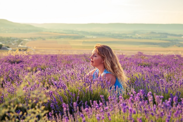 Girl in a lavender field at sunset. Sunny summer evening in Crimea.