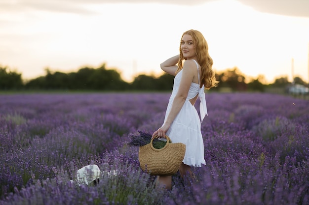 Girl in a lavender field Woman in a field of lavender flowers at sunset in a white dress France Provence