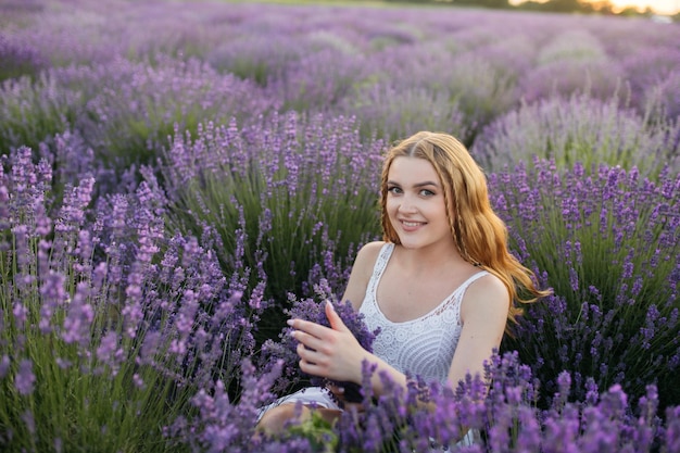 Girl in a lavender field Woman in a field of lavender flowers at sunset in a white dress France Provence