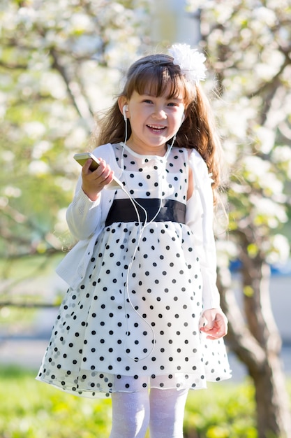 The girl listens to music from her mobile phone.