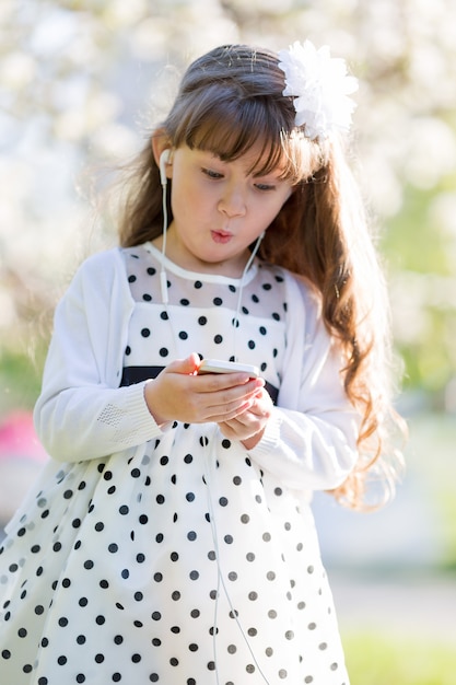 The girl listens to music from her mobile phone.