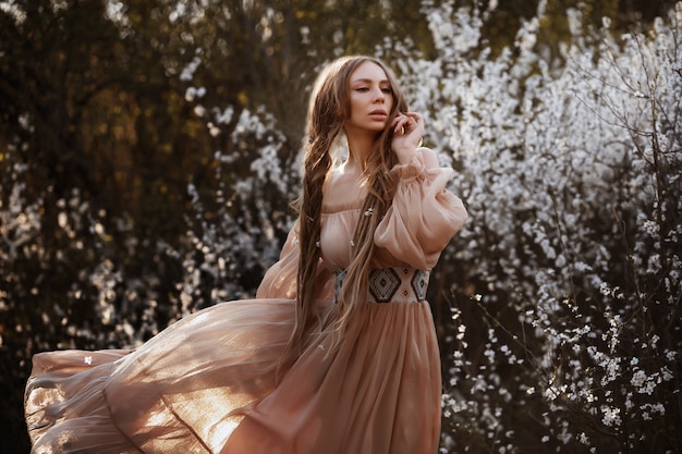 girl in a long dress. spring portrait in the garden. beautiful ethnic dress