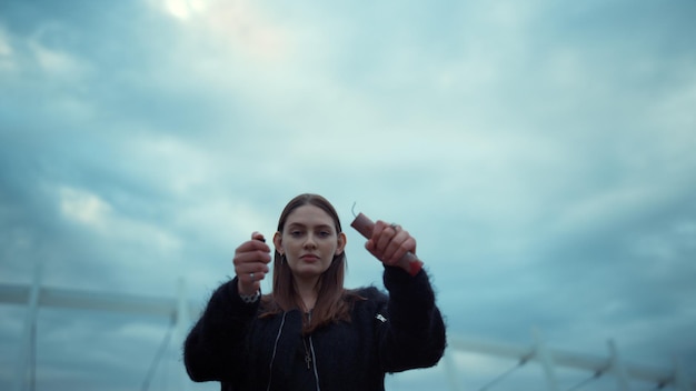 Girl looking at camera on city street Woman holding lighter and smoke bomb