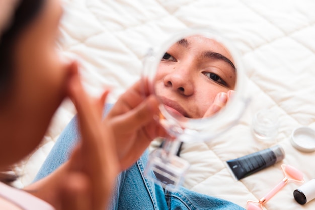 A girl looking at her face in the mirror