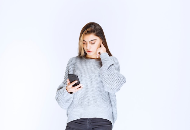 Girl looking to the messages or comments at her smartphone.