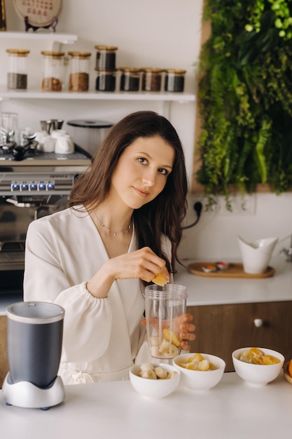 A girl makes a detox cocktail of fruit in the kitchen Diet for weight loss