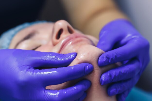 A girl makes a facial massage in a beauty salon skin care concept spa concept treatment face massage