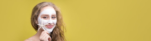 The girl makes procedures with a cosmetic mask on her face