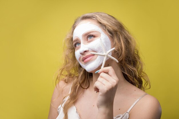 Photo the girl makes procedures with a cosmetic mask on her face.