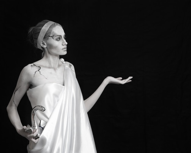 a girl in makeup for an antique ancient statue holding faucet with free space for text