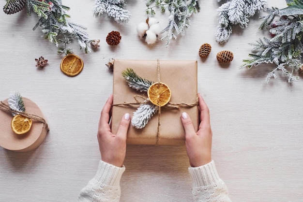 Girl making gift box. Top view of christmas festive frame with new year decorations.