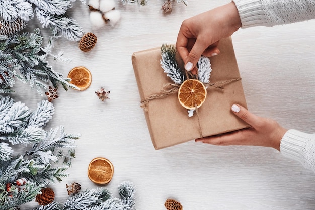 Girl making gift box. Top view of christmas festive frame with new year decorations.