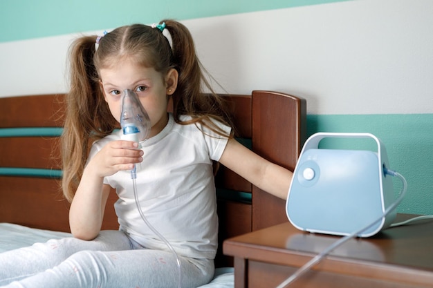 Girl making inhalation with nebulizer at home