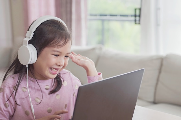 Girl making video calling with laptop at home