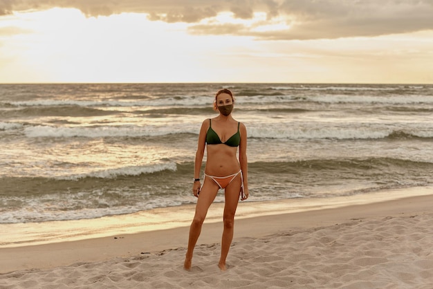 Girl in a mask and swimsuit on the beach