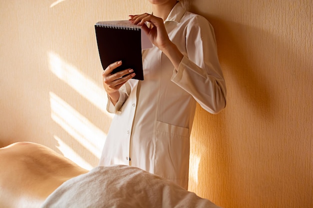 Girl massage therapist holds a notebook in her hands to record clients