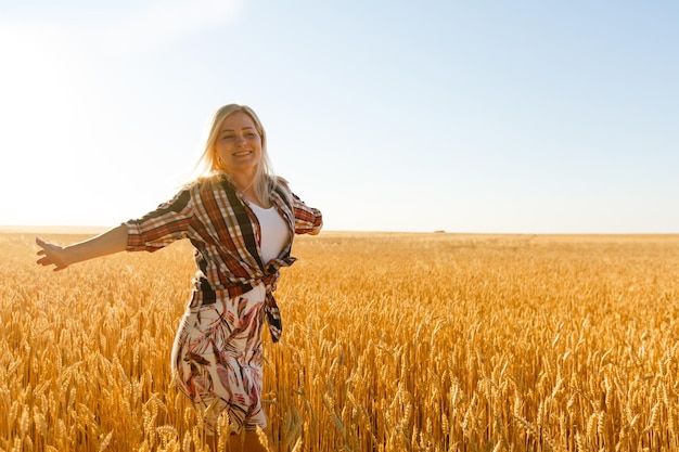 A girl in the midst of wheat spikelets. Caucasian woman posing with spikelets outside.