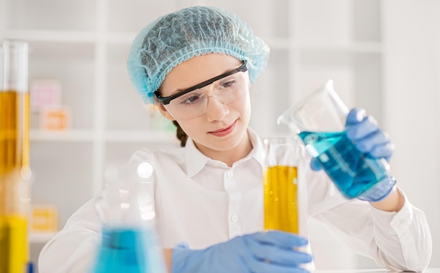 Girl mixing chemical substances in laboratory