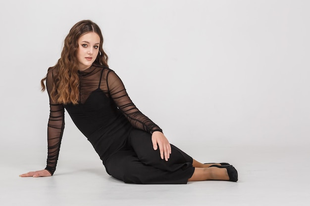 Photo girl model in black shirt trousers posing relaxed in studio on white background