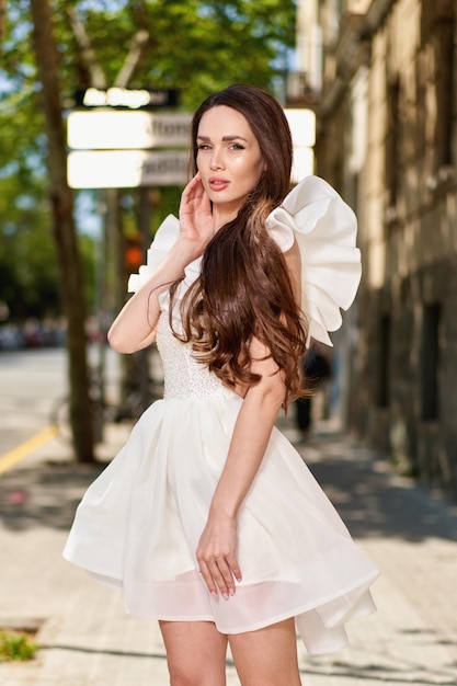 Girl model in a white dress on the street