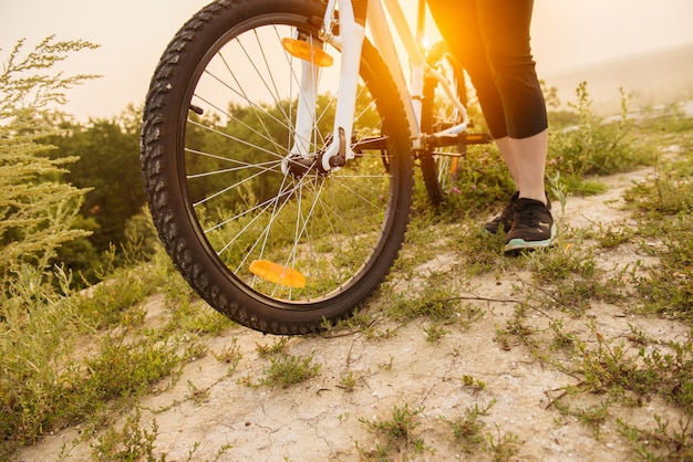 Girl on mountain bike rides on the trail on a beautiful sunrise.