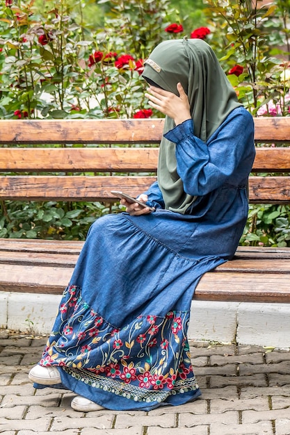 Girl in a Muslim dress in a city park in spring