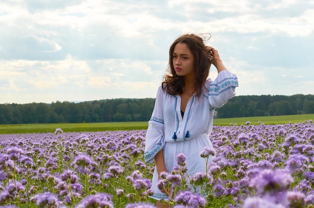 A girl in the national costume of Ukraine in a field of flowers