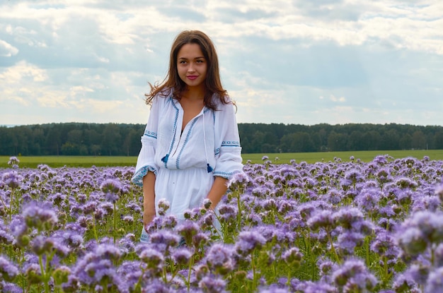 A girl in the national costume of Ukraine in a field of flowers