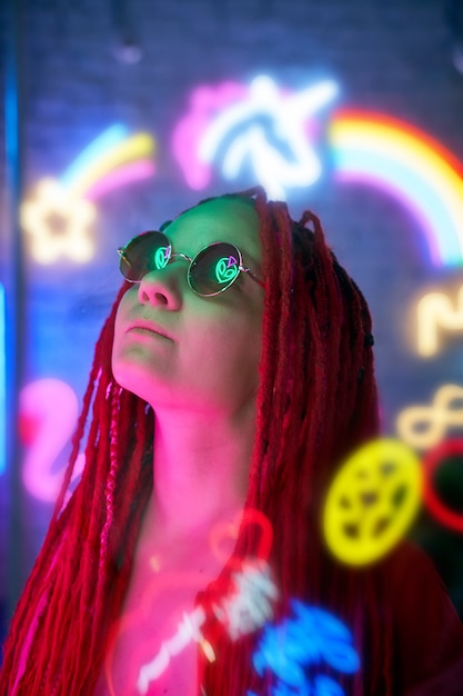 Girl in neon lights, beautiful woman in sunglasses, with pink hair, with dreadlocks pigtails,