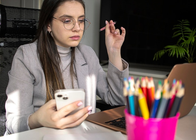 Girl in office clothes looking at a laptop screen