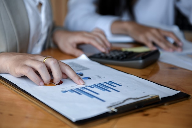 Girl office using a calculator to graphs analysis.