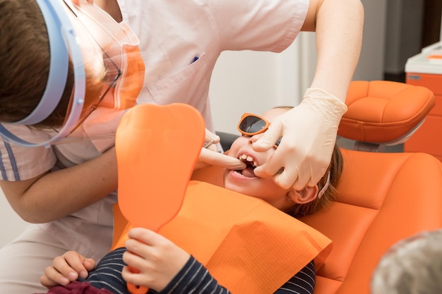 Girl opened her mouth to check with a dentist monitor teeth healthChildren tooth care and hygiene