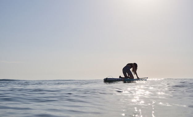 Girl on a paddle board at sunrise