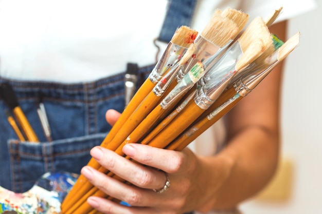 Photo girl painter holds a brush