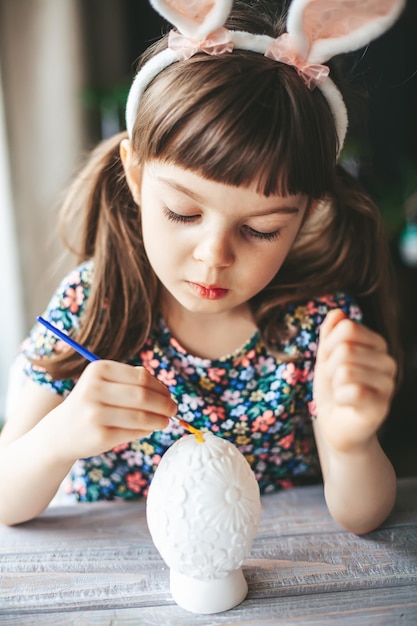 Girl painting plaster easter egg