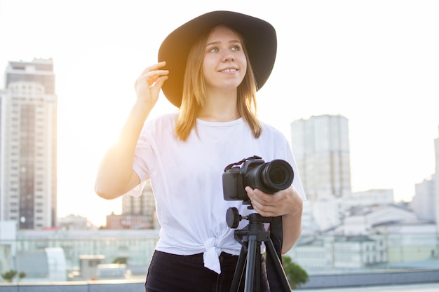 Girl photographer with a camera and a tripod