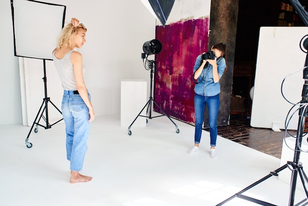 Girl photographer works in Studio with a model