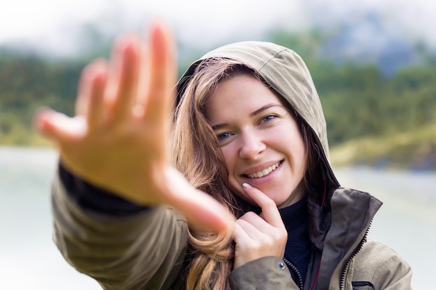 The girl playfully covers her face from the camera with her hand