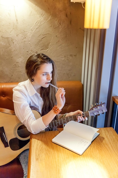 Girl playing guitar at cafe