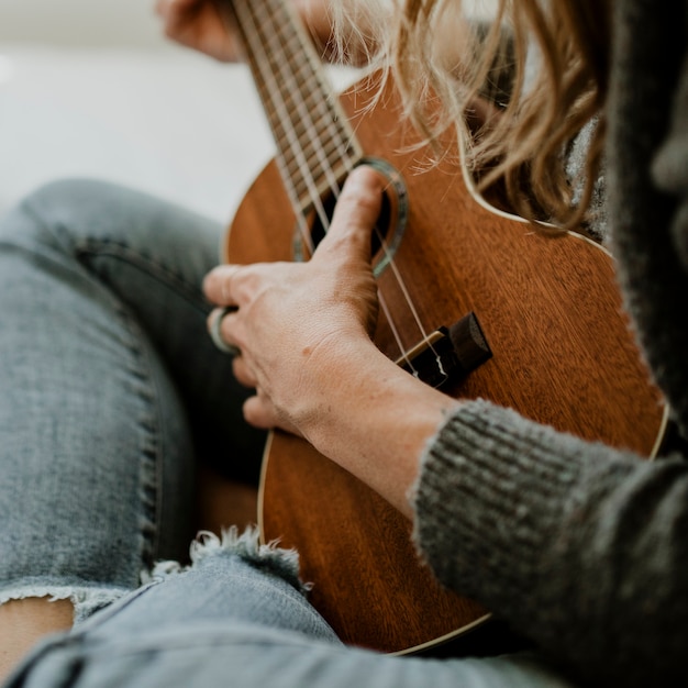 Girl playing ukulele on her bed