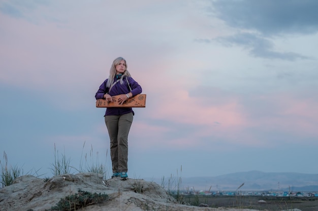 Girl plays the psaltery in the mountains of the Altai Republic