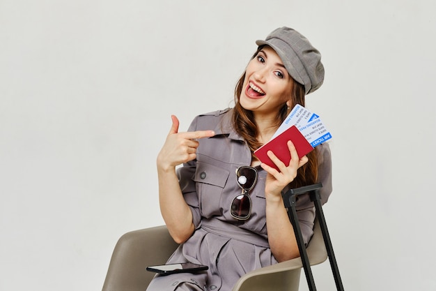 Girl points finger to passport with tickets as a concept time for travel.