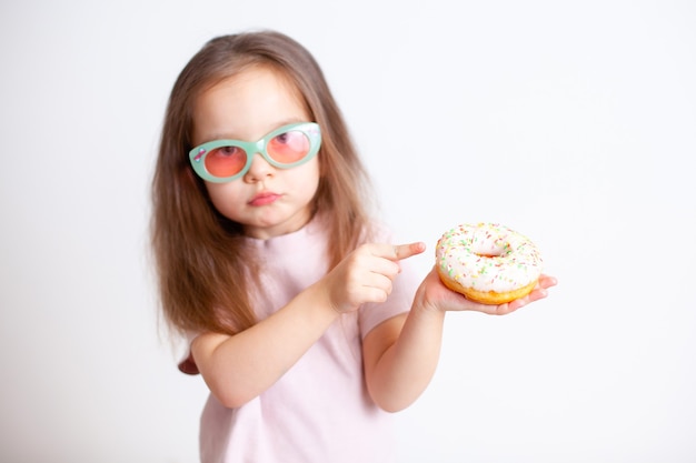 The girl points her finger at the doughnut with a disgruntled face Emotions Harmful food Proper nutrition Baby food